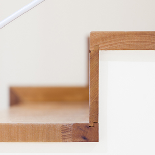 Carpinteria BRAIPONT: Detalle escalera revestida en madera de iroko.
